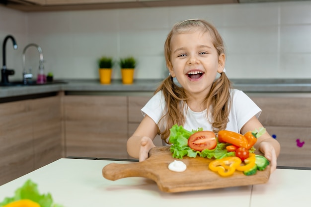 写真 新鮮な野菜とボードを保持している女の子。