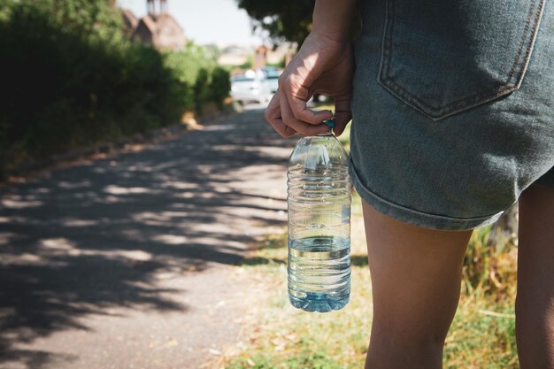 写真 公園で水のボトルを保持している女の子