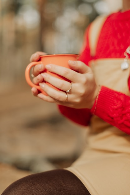 写真 彼女の手でお茶と熱い鉄のマグカップを保持している女の子