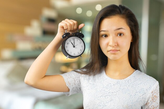 Girl holding alarm clock in hand