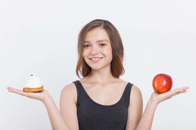 Girl holding apple and cupcake