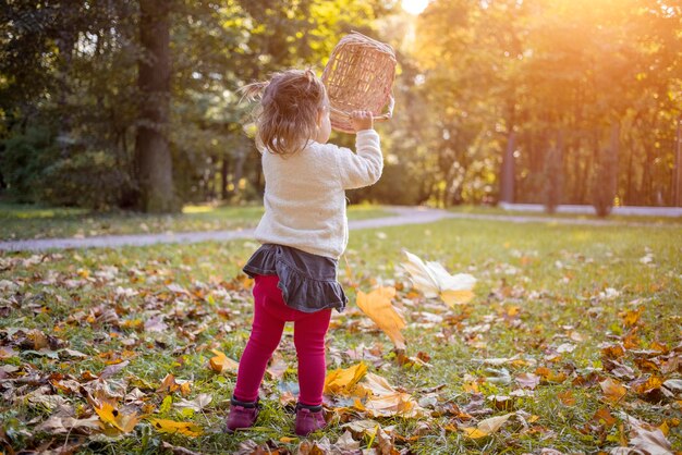 Girl holding basket in park during autumn