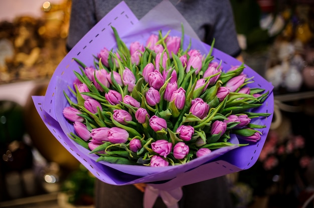 Girl holding a beautiful bouquet of violet tulips