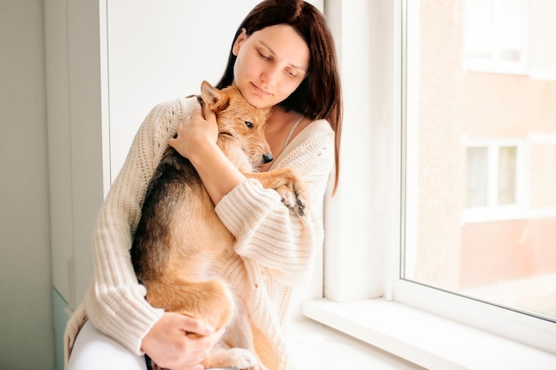 girl holding a beautiful street mix dog in her arms, helping a dog abandoned dog