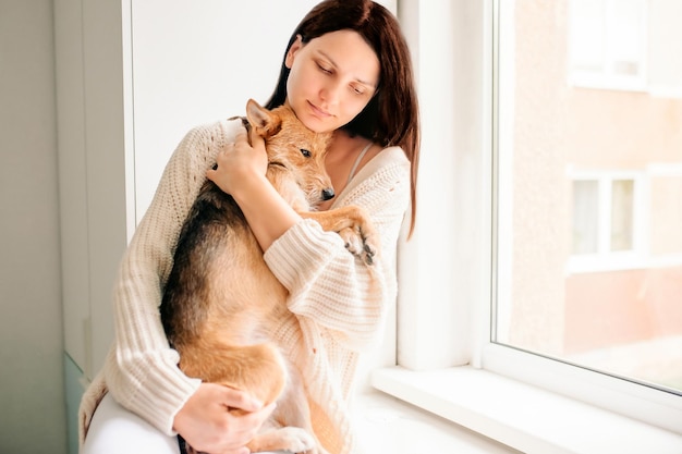 Foto ragazza che tiene in braccio un bellissimo cane da strada, aiutando un cane abbandonato