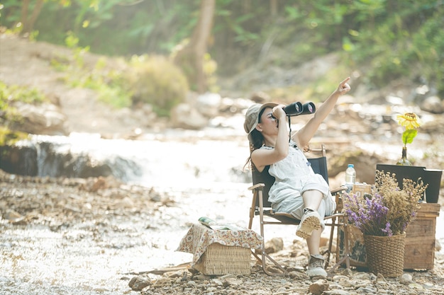 Girl holding binoculars by the water