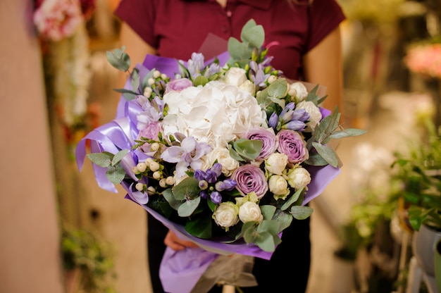 Girl holding a bouquet of roses, hydrangea, orchid, eustoma, peonies