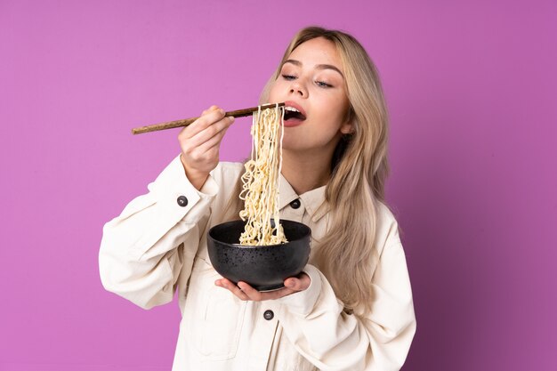 Girl holding a bowl full of noodles