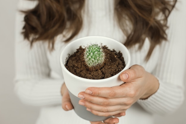 girl holding a cactus in a pot