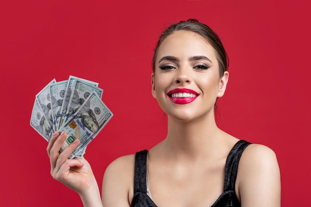 Girl holding cash money in dollar banknotes Woman holding lots of money in dollar currency Luxury beauty and money concept Woman with dollars in hand Portrait woman holding money banknotes