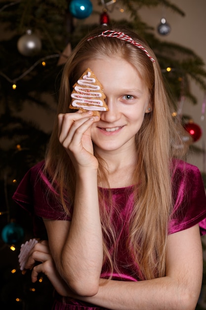 クリスマスのジンジャーブレッドを手に持っている女の子