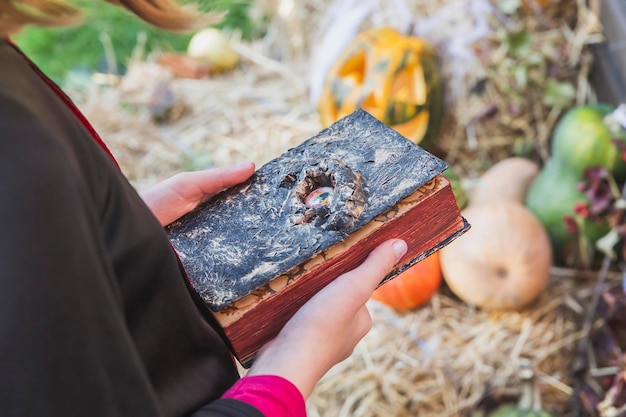 girl holding a creepy book with an eye in her hands