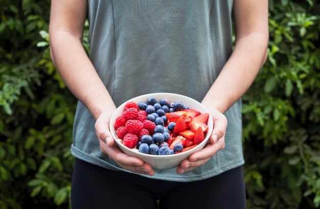 Girl holding a cup with berries