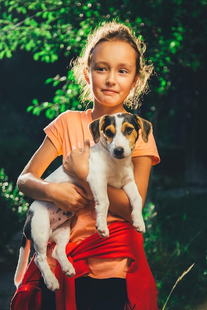 笑顔でカメラを見ている犬を抱いた女の子