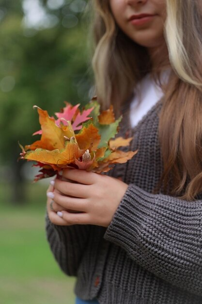 girl holding dried leaves in her hands