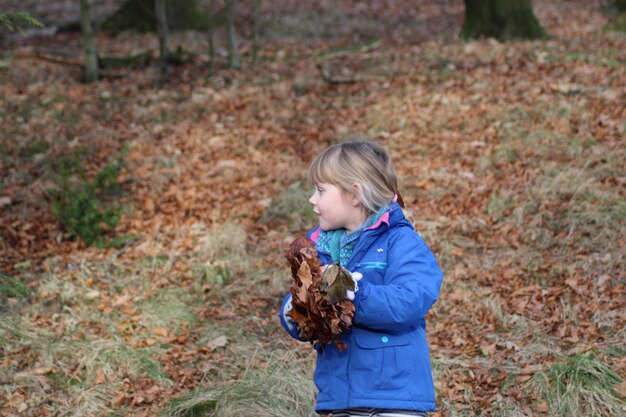 Photo girl holding dry leaves during autumn