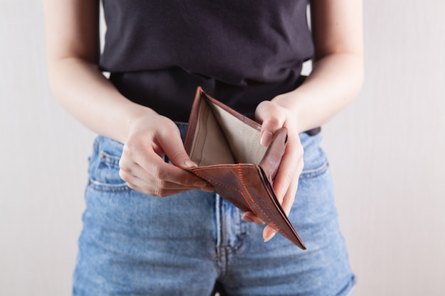 Girl holding an empty wallet in her hand