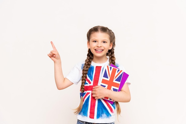 A girl holding an English book points to your advertisement on an isolated background Teaching children English