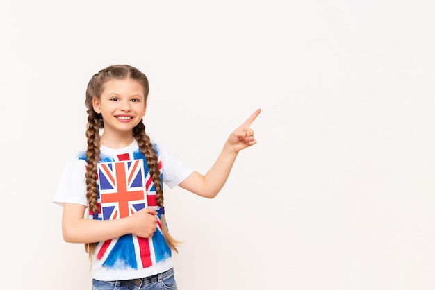 A girl holding an English book points to your advertisement on an isolated background Teaching children English