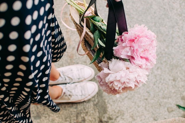 Girl holding flowers legs close up
