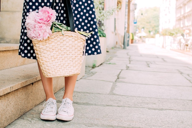 Girl holding flowers legs close up