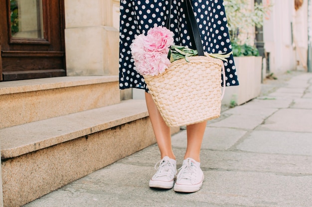 Girl holding flowers legs close up