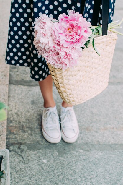 Girl holding flowers legs close up