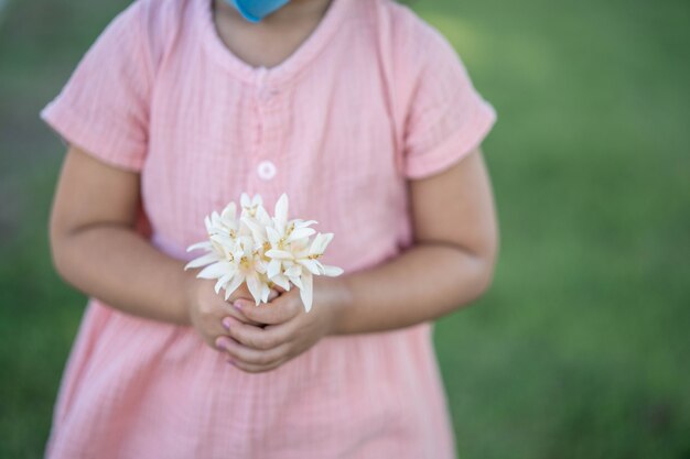 Girl holding a frangipani in the park