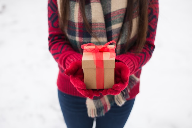 A girl holding a gift in her hands on the street in winter