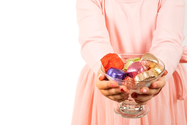 A girl holding a glass bowl of candy