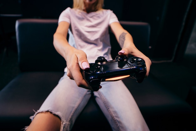 Girl holding in hands gamepad and playing videogames