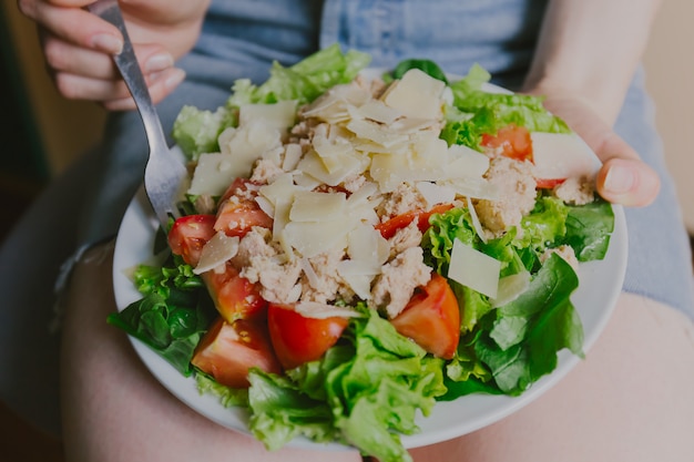 Ragazza che tiene insalata sana pronta da mangiare