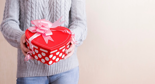 Girl holding a heart-shaped gift in her hands