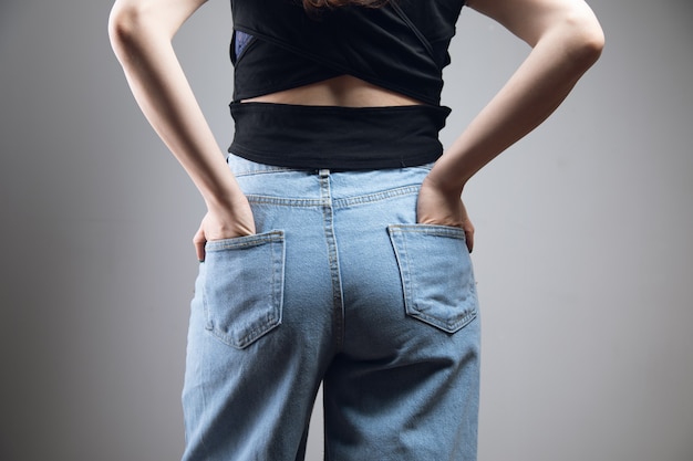 Girl holding her hands in her back pockets