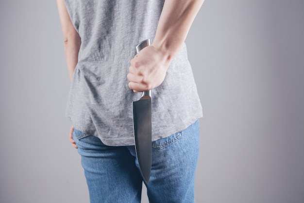 Девушка держит кухонный нож, чтобы защитить себя