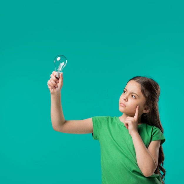 Photo girl holding lamp and thinking