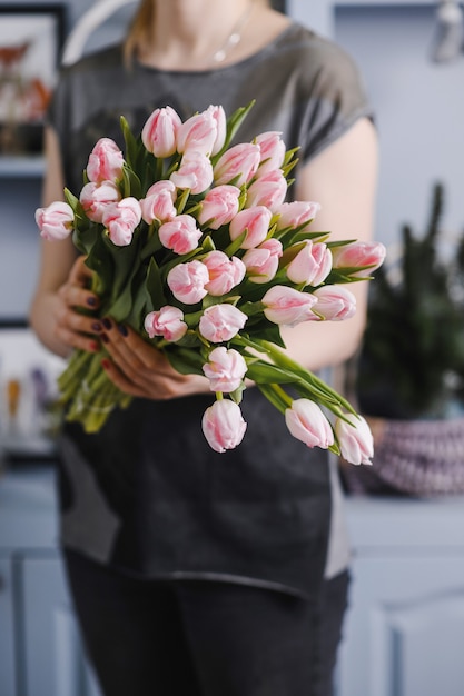 彼女の手でチューリップの大きな花束を持っている女の子。