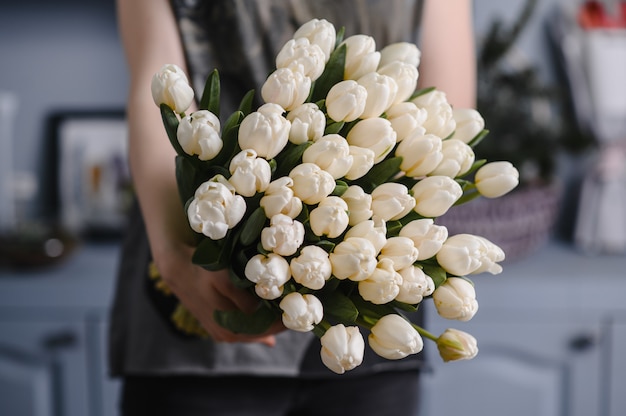 Girl holding a large bouquet of tulips in her hands