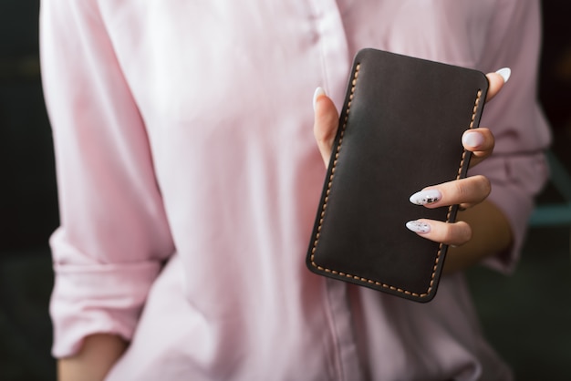 Girl holding leather case for the phone