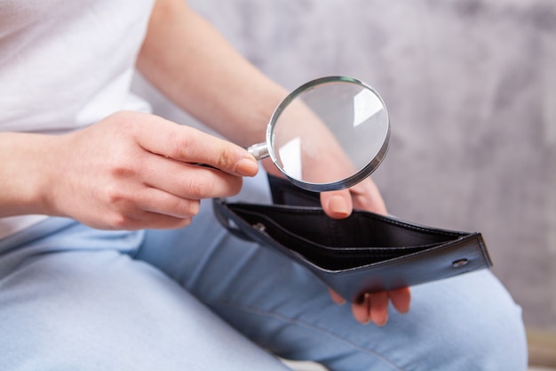 Girl holding a magnifying glass and wallet