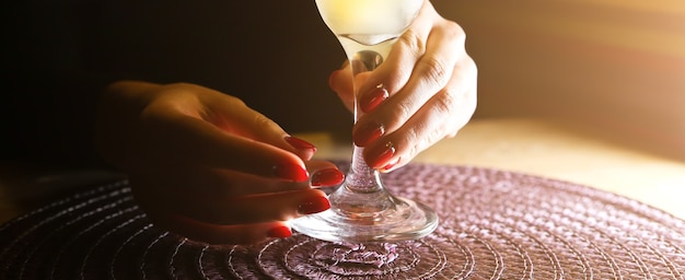 Girl holding margarita cocktail on the table in the restaurant. Alcoholic drinks. Beautiful hands.