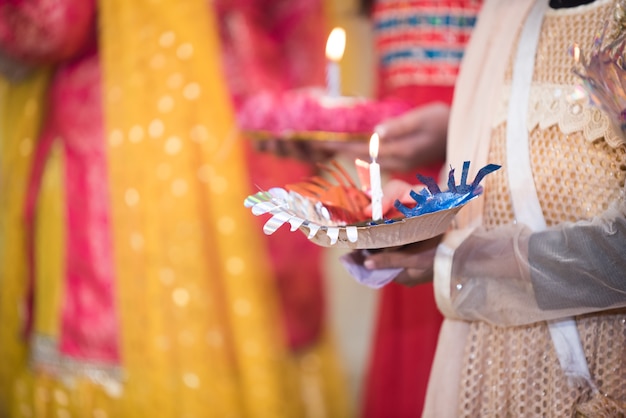 Photo girl holding mehndi henna tray with candles light