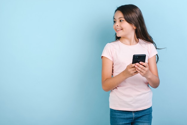 Girl holding mobile phone with happy looking sideaway. 