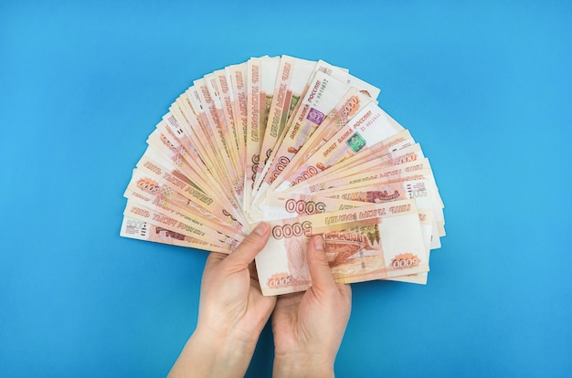 Girl holding money in her hands on a blue background