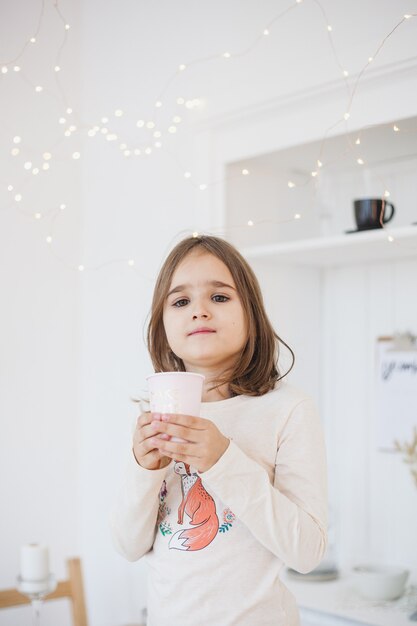 Ragazza che tiene una tazza a casa a natale