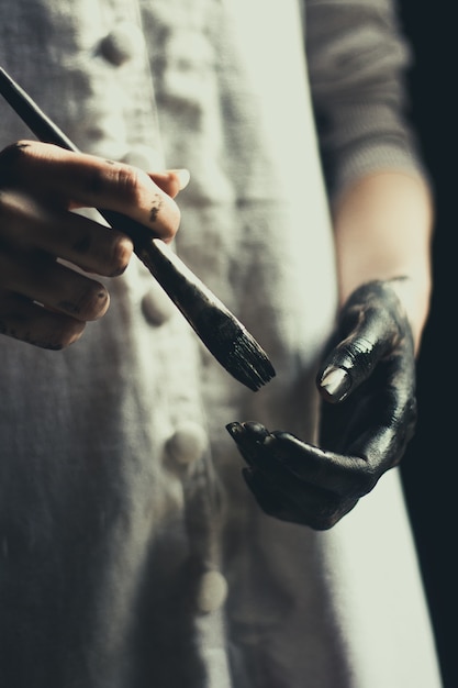 Photo girl holding paint brush in hand