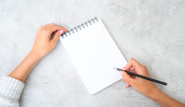 Girl holding a pencil in a hand with notebook