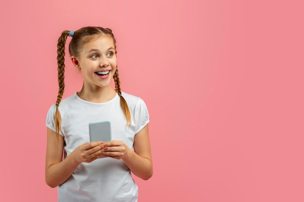 Girl holding phone excited by content on pink