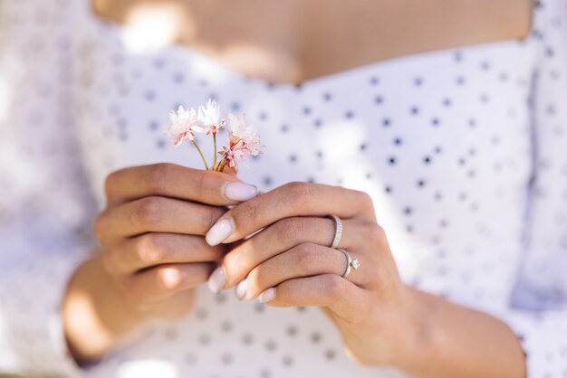 girl holding pink flower petals in her hands