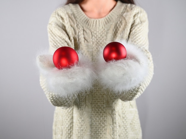 Girl holding a red ball in warm gloves. High quality photo